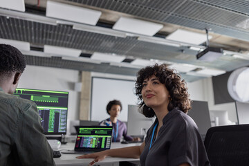 Female computer programmer looking up in a busy office 