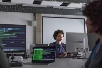 African American woman computer programmer working in a busy office