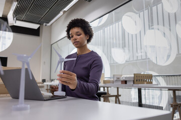 Young architect looking at wind turbines for sustainable living