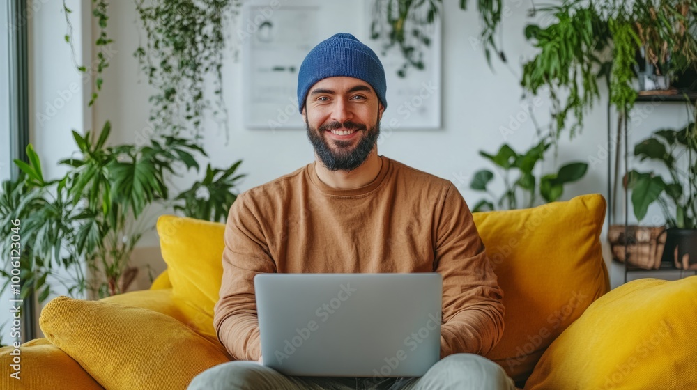 Poster a man is sitting on a couch with a laptop in front of him