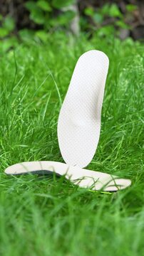 Orthopedic insoles for shoes on a background of green grass