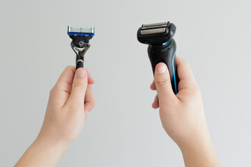 Man's hands holding razor and electric trimmer