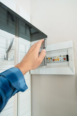 Man standing by an electrical panel, repairing it after a power failure, emphasizing safety...