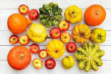 An assortment of apples, quince, and pumpkins on a wooden background