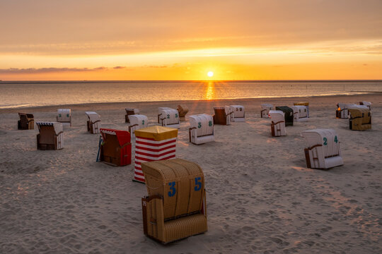 Beach chairs on the island of Borkum in Lower Saxony, Germany, at sunset.