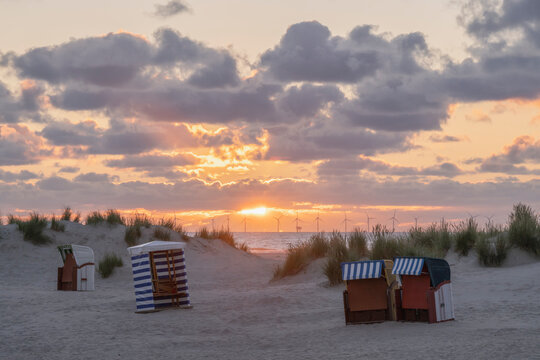 Scenic sunset at the beach with chairs on the Island of Borkum in Lower Saxony, Germany.