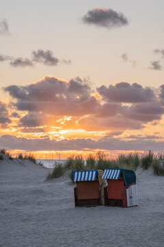 Sunset on the beach with beach chairs on the Island of Borkum, Lower Saxony, Germany.