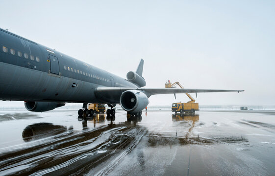 Military tanker and transport plane to refuel military fighter planes on a foggy winter day.
