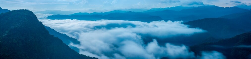 A breathtaking panoramic view of a sea of clouds below a crescent moon and a starry night sky. The silhouette of distant mountains adds depth and drama to this serene landscape. Xindian, Taiwan.