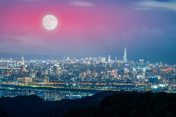 Obraz premium A golden autumn moon hangs over the Taipei skyline, casting a warm glow on the city. The scene captures the tranquility of an autumn evening. Taipei City, Taiwan.