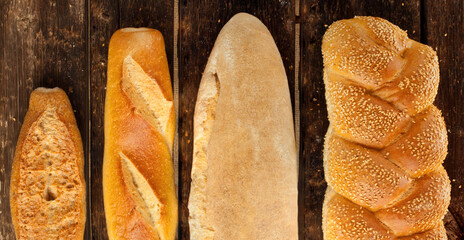 Variety of freshly baked bread loaves on rustic wooden table
