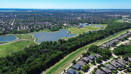 New development two story suburban houses with swimming pool near green park urban forest walking biking paths, large lake pond suburb Dallas Fort Worth Metroplex, upscale Coppell Texas, aerial