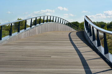 Wooden footbridge in the sunlight at the summer day. European usual bridge made from wood