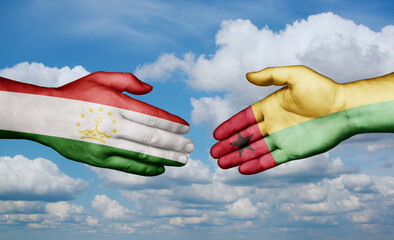 Guinea-Bissau and Tajikistan country handshaking with flags, consensus concept international co-operation illustration