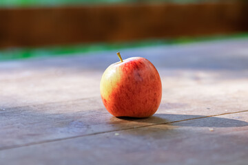 Fresh apple on a wooden background. Fruits with copy space, concept on the theme of healthy nutrition and diet. Outdoor, side view.