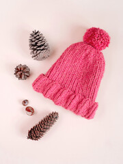Pink knitted hat on light background. Flat lay. Top view