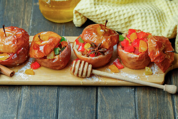 Baked Apples with honey and candied fruits on wooden board. Top View.