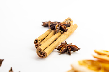Cut orange and different spices  on white background. Traditional festive winter beverage.Cinnamon, dried orange, anise and cloves