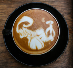 Close up black coffee cup with latte art on wood tab