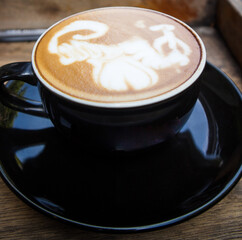 Close up black coffee cup with latte art on wood tab