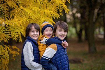 Fototapeta premium Happy family, mother with children, having their autumn pictures taken in the park