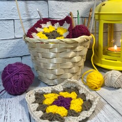 Cozy autumn photo with crocheting, clews of wool, basket, candle light