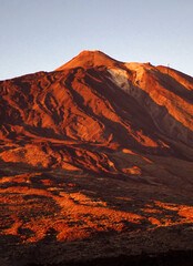 Naklejka premium A volcano Teide and stunning mountains with lava formations at sunset/