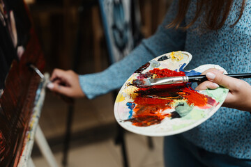 Artist mixing vibrant paint colors on a palette during creative session