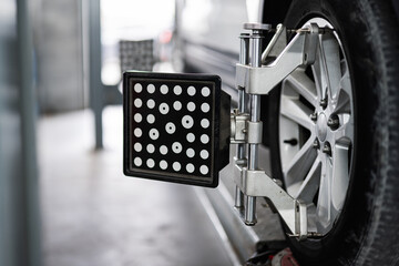 Close-up of a car wheel alignment process using advanced equipment in an automotive repair shop....