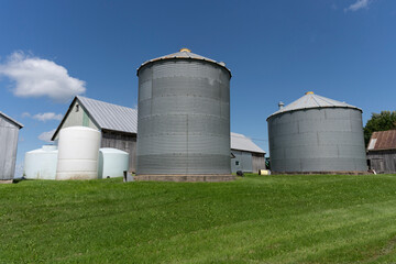 Some farm metal building and water tanks on a blue sky © Richard Nantais