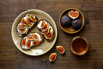 Breakfast with figs and cheese toasts with honey, top view