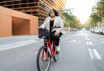 Woman riding a bicycle on city street, looking away