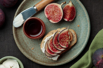 Close-up view of sandwich with fresh fig slices, cream cheese spread and honey on white bread....