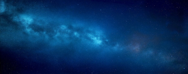 A dark blue background with stars, galaxies, and space dust. Viewing the universe in an abstract manner.