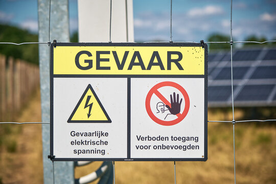 Danger sign 'Gevaar' on a fence surrounding a solar farm in Drenthe, Netherlands
