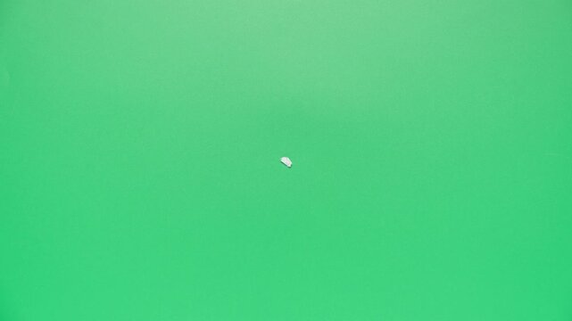 Stop motion animation of crumpled paper on a green background