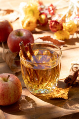 Glass of apple cider outdoors on wooden table