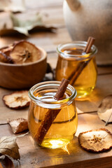Glass of apple cider outdoors on wooden table