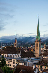 Fototapeta premium Catholic Church clock tower in a European city. Moody light, summer morning, high vantage point, no people