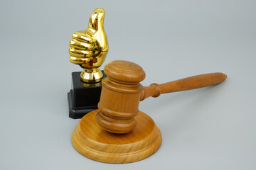 Best attorney or lawyer concept. Judge gavel with thumbs up cup on gray background. 