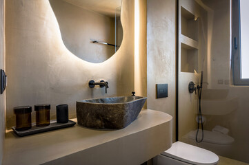 Modern bathroom interior design with cave-like aesthetic, featuring soft beige tones creating warm...