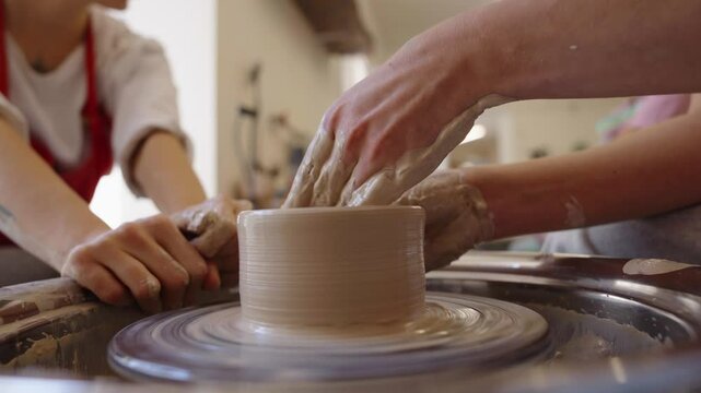 Crafting pottery on a wheel at a pottery studio in the afternoon