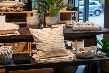 Decorative pillows and ceramic vases on display in home decor store.