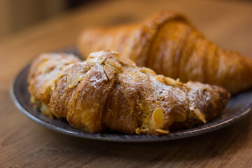 close-up of croissants stacked on wooden table.