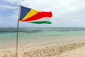 The flag of Seychelles is on the beach