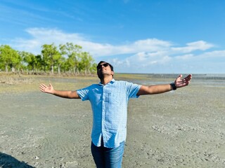 South asian young traveler enjoying leisure time in a sea beach 