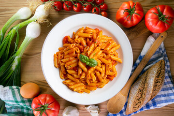 Macaroni with tomato and basil aroma. Top view table with  decorations.