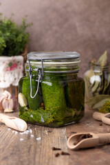 Half-sour dill pickle (quick pickled cucumbers) in a jar with seasonings, spices and herbs. Homemade seasonal preparations. Traditional canning of vegetables. Selective focus, close-up.