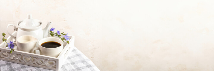 Chicory tea, teapot, milk jug on white wooden tray on plaid napkin. Banner. Copy space.