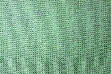 Close-up of green diamond plate metal texture with worn surface.